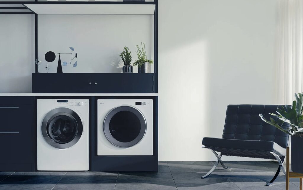 モダンなインテリア空間にビルトインされた洗濯機とガス衣類乾燥機。ブラック家具とレザーチェアがあるスタイリッシュな室内。