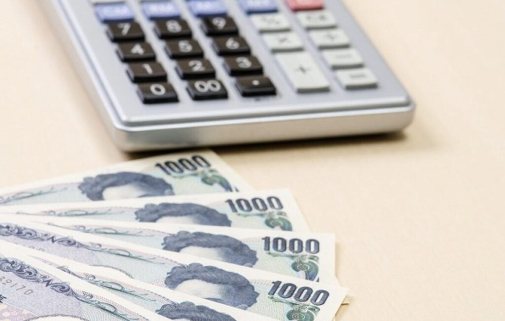 電卓と千円札が並べられた写真。設置費用やランニングコストをイメージしたビジュアル。
