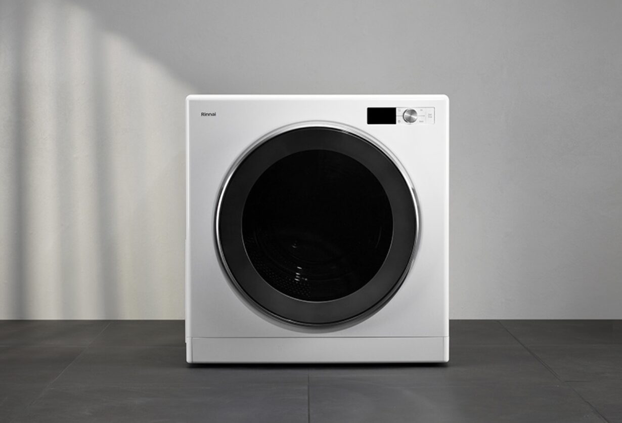 白い壁とグレーの床のシンプルな空間に設置されたリンナイ製のドラム式ガス衣類乾燥機。正面に大きなブラックガラスドアと操作パネルが配置されたミニマルデザインの外観。