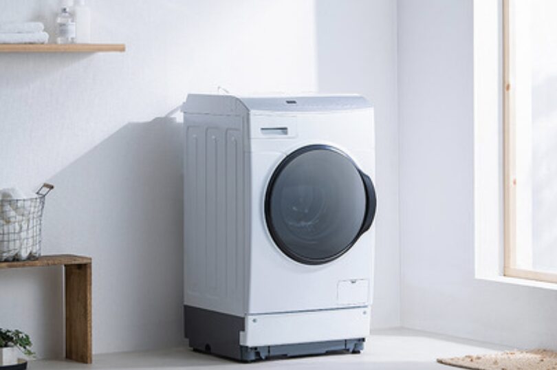 窓のある明るい室内に設置された白いドラム式洗濯機の外観。