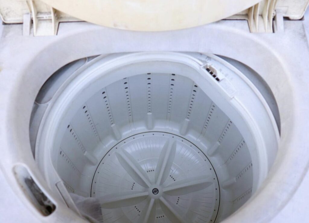 空の縦型洗濯機の洗濯槽内部を上から見た状態。