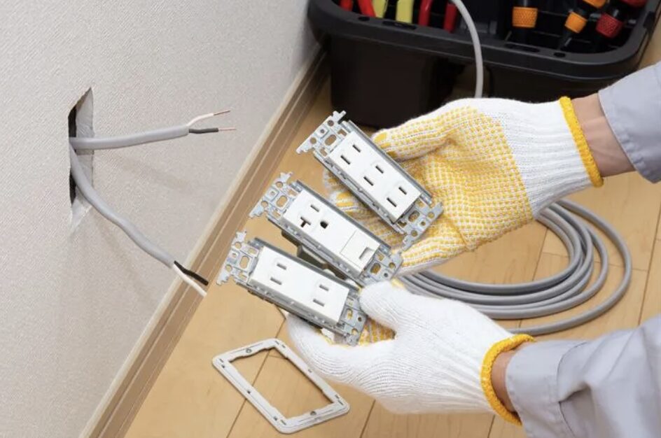 複数のコンセントユニットを手に持ち、壁内配線と接続前の状態を確認している様子。
