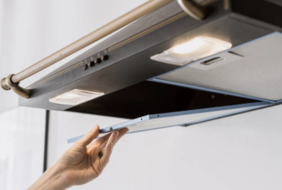 レンジフードの整流板を手前に開いて取り外している様子。