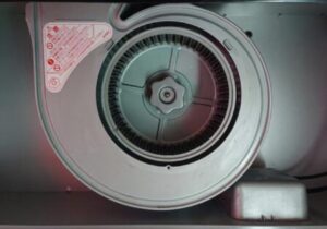 換気扇のシロッコファンを正面から撮影した画像。円形のファンと中心の固定ノブが見える構造部分のアップ。