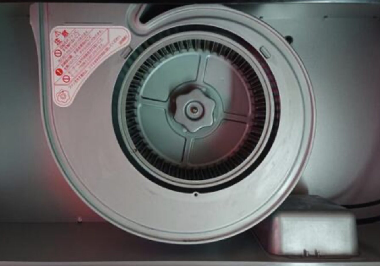 換気扇のシロッコファンを正面から撮影した画像。円形のファンと中心の固定ノブが見える構造部分のアップ。