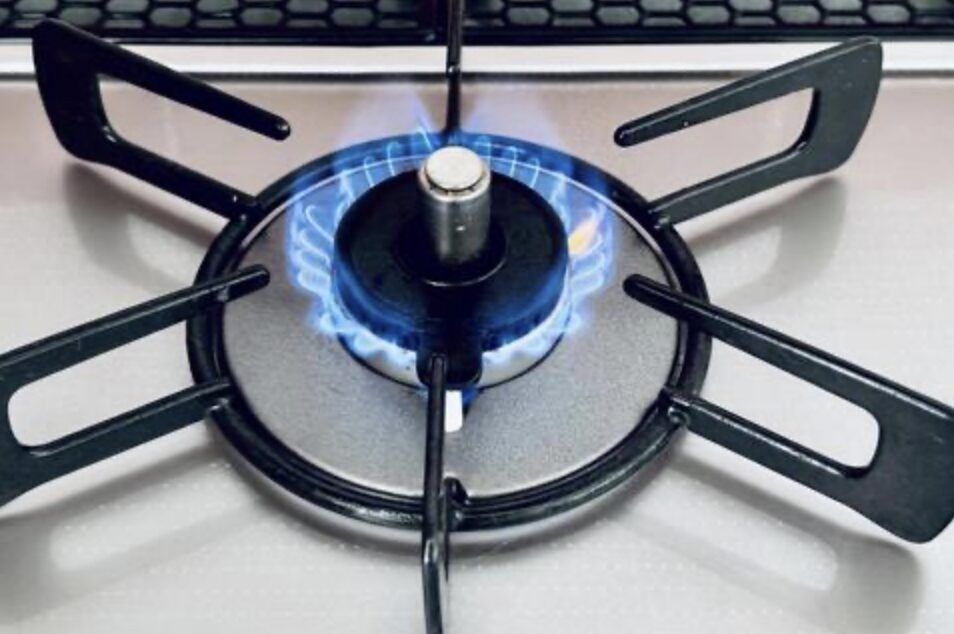 ガスコンロの五徳とバーナー中心部から青い炎が均一に出ている様子の接写。