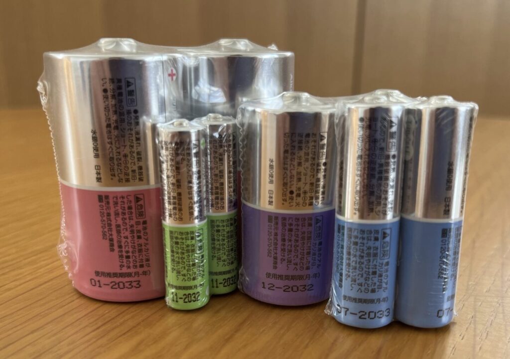 単1・単2・単3・単4サイズの乾電池が未開封パックの状態で並べられている写真。
