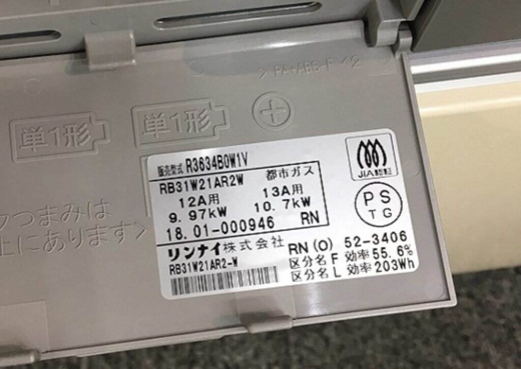 ガスコンロ内部の型式ラベル表示。都市ガス12A・13Aの区分と出力値が記載された銘板部分。