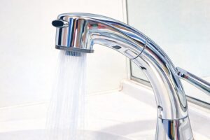 シンプルなイラスト風で描かれたクロームの蛇口から水が流れている様子