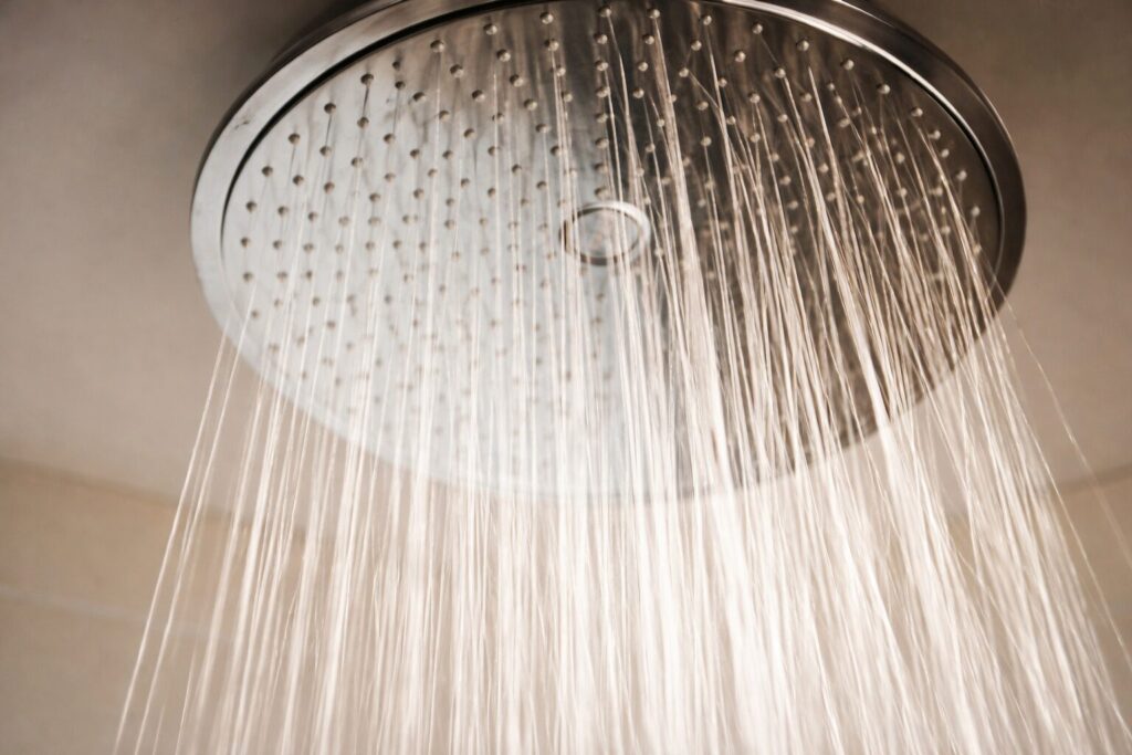 天井に設置された大型のレインシャワーヘッドから均一に水が流れ落ちている様子