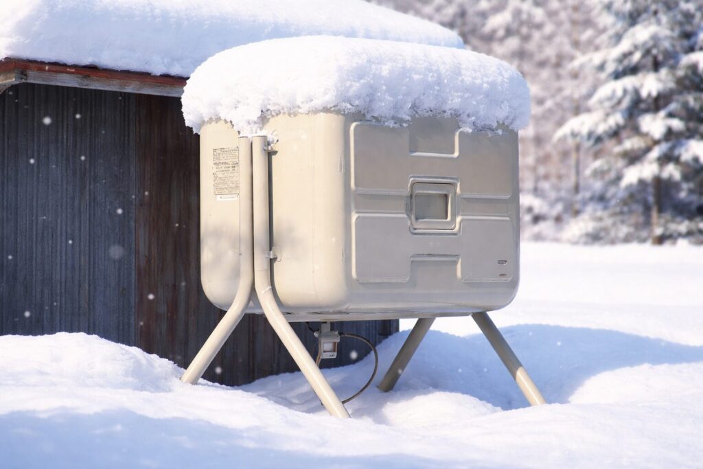 雪が積もった屋外の灯油タンクが冬の風景の中に設置されている様子