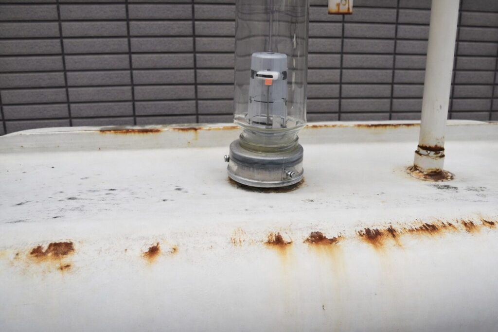 灯油を運搬するタンクローリー車のシンプルなイラストで、白い車体に赤いラインと危険物表示が描かれているデザイン