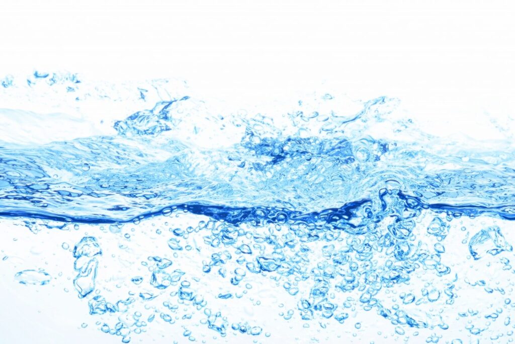 白背景の中で青い水が横方向に広がり、波打つ水面と細かい気泡が広がる高精細な水の動きのイメージ