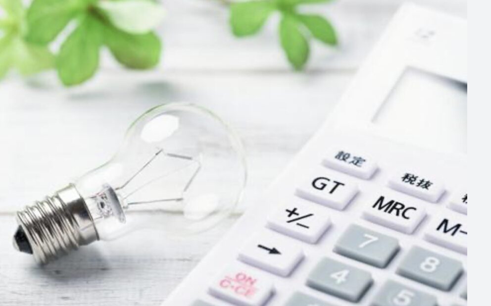 電卓と電球が置かれた節電や電気料金の計算をイメージした写真