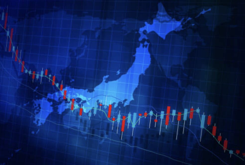日本地図の背景にローソク足チャートが重なった金融市場のイメージ