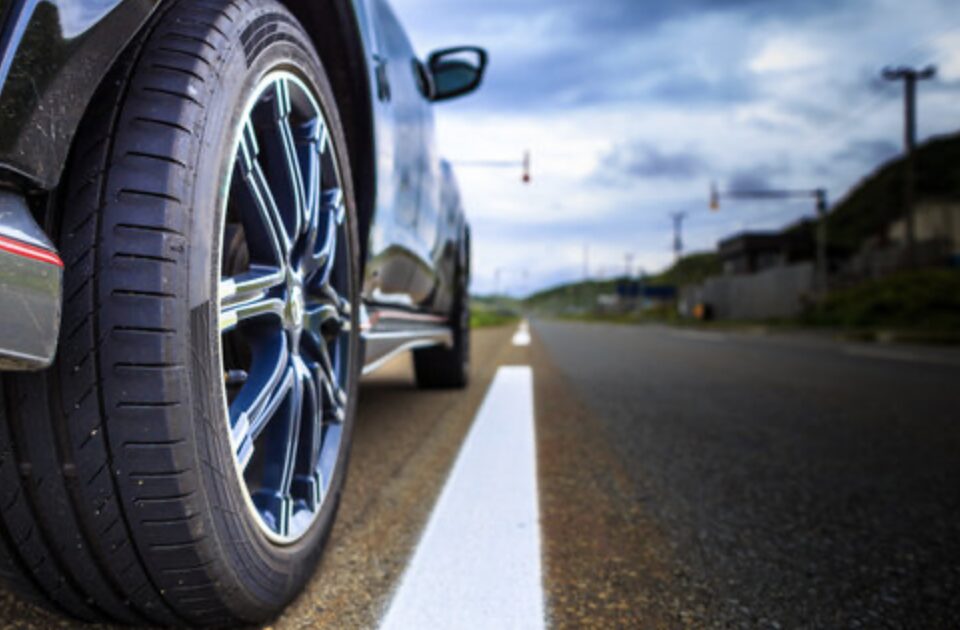 道路を走行する車のタイヤを低い位置から撮影した走行イメージ