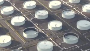 石油コンビナートに並ぶ大型の石油タンクを上空から撮影した様子