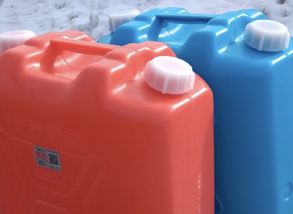 赤と青の灯油ポリタンクが雪の上に置かれている様子。冬の暖房用燃料として使われる灯油をイメージした写真