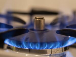 ガスコンロのバーナーから青い炎が出ている様子を近くから撮影した写真