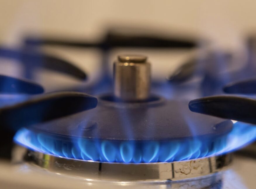 ガスコンロのバーナーから青い炎が出ている様子を近くから撮影した写真