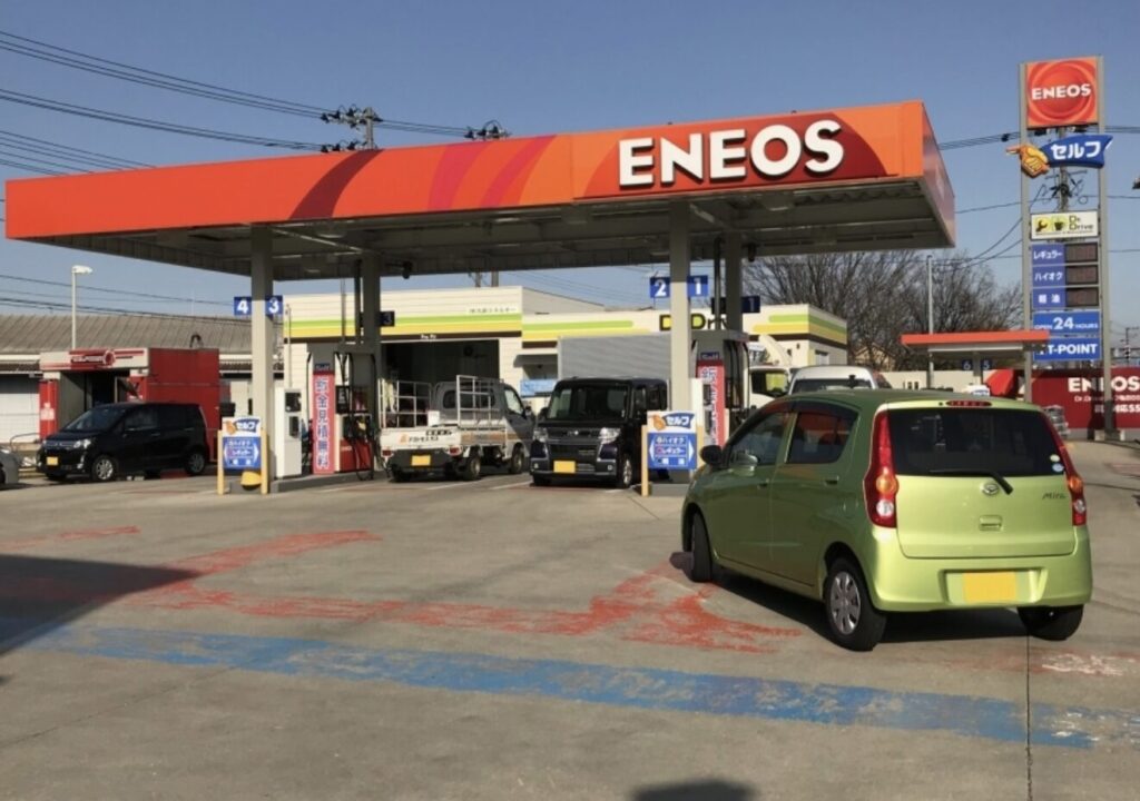 ENEOSのガソリンスタンドに車が給油に訪れている風景。