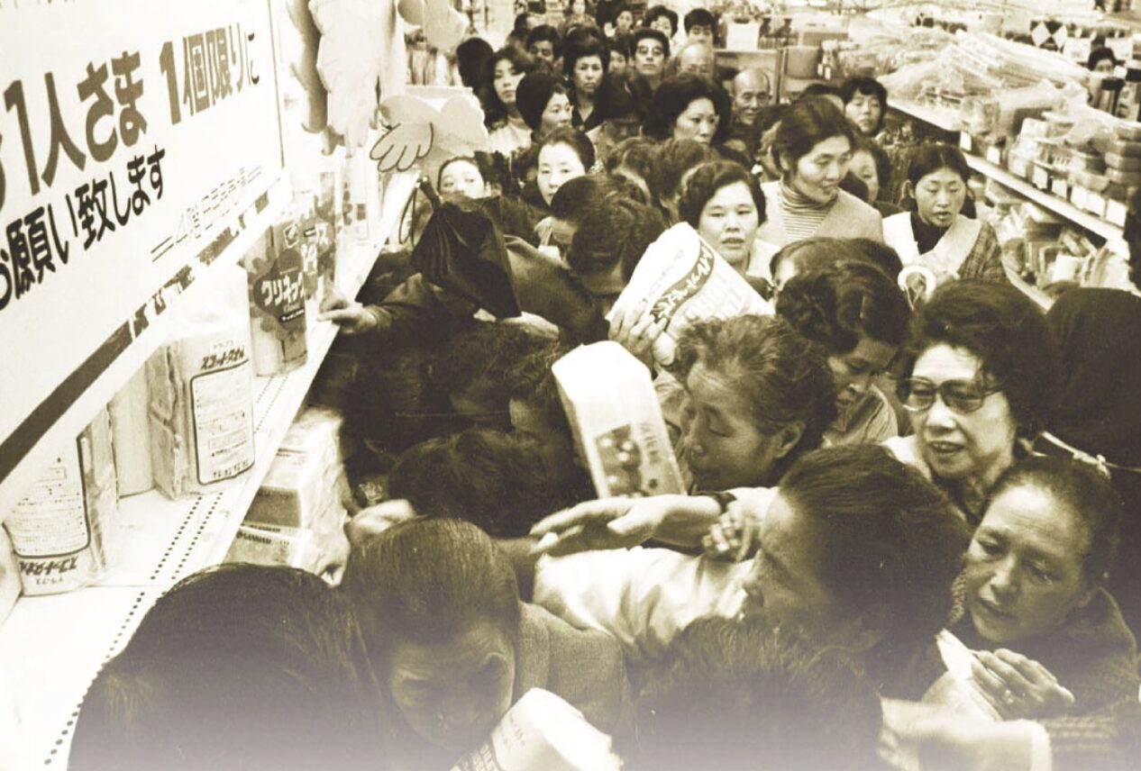 商品棚に人が押し寄せて買い物客が混雑している店内の様子