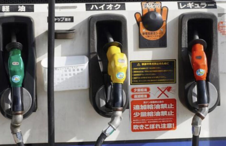 ガソリンスタンドの給油機に並ぶ軽油・ハイオク・レギュラーの給油ノズル
