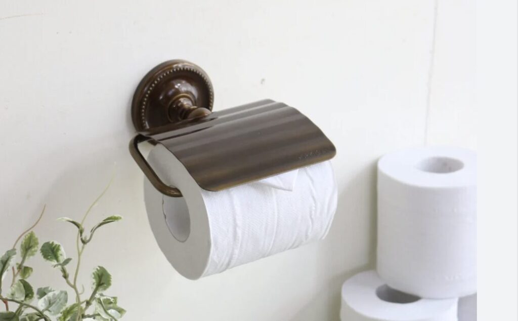 トイレの壁に取り付けられたホルダーにセットされたトイレットペーパーと予備のロール