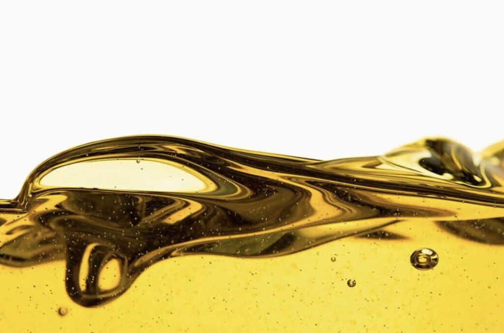黄金色の液体燃料が波のように流れる様子を接写したナフサのイメージ