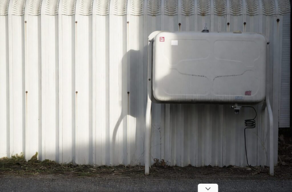 建物の外壁前に設置された据え置き型の屋外灯油タンク