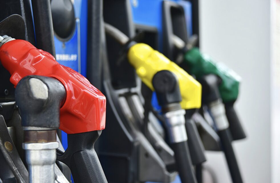 赤・黄・緑の給油ノズルが並ぶガソリンポンプの接写。燃料種別ごとの色分け