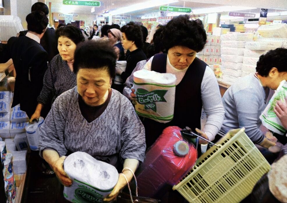 トイレットペーパーを買い求めて人が密集する店内で、商品を手に取る来店客の様子