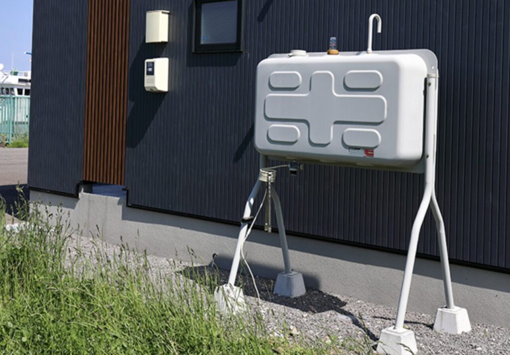 住宅外壁横に設置された据え置き型の灯油タンクと配管設備