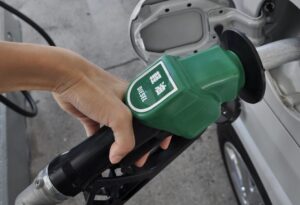 手で持った軽油ノズルを車の給油口に差し込んでいる給油作業の様子