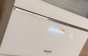 パナソニック製の食洗機の操作パネル部分を拡大した写真。ランプが点灯しており、運転状態が表示されている様子。