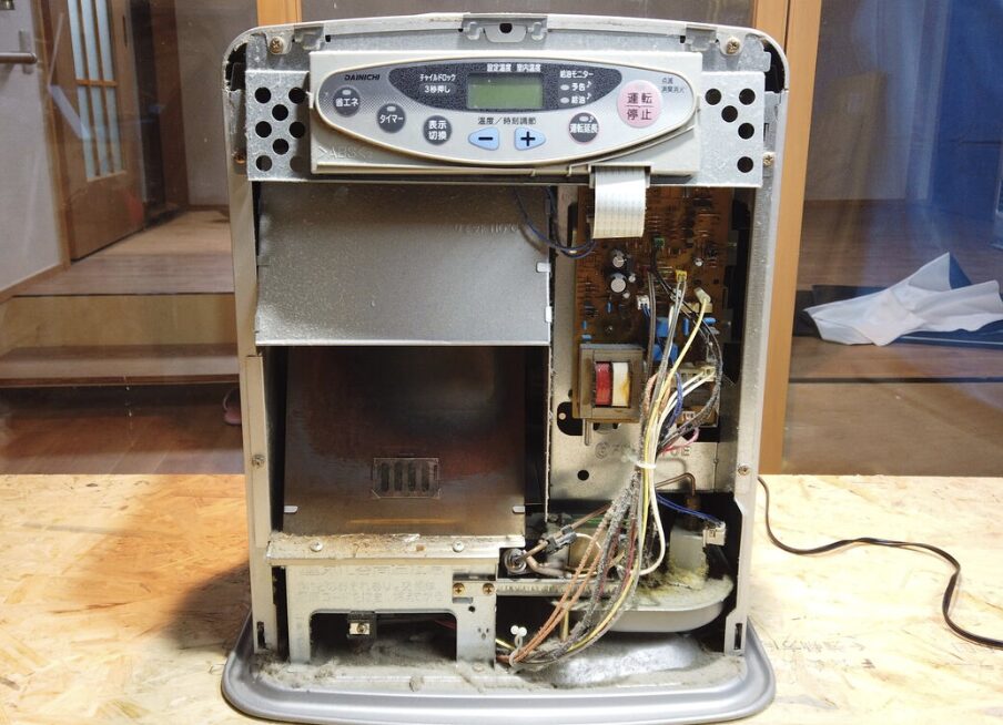 石油ファンヒーターの外装を外した内部構造と配線・基板・燃焼部の状態が見える様子