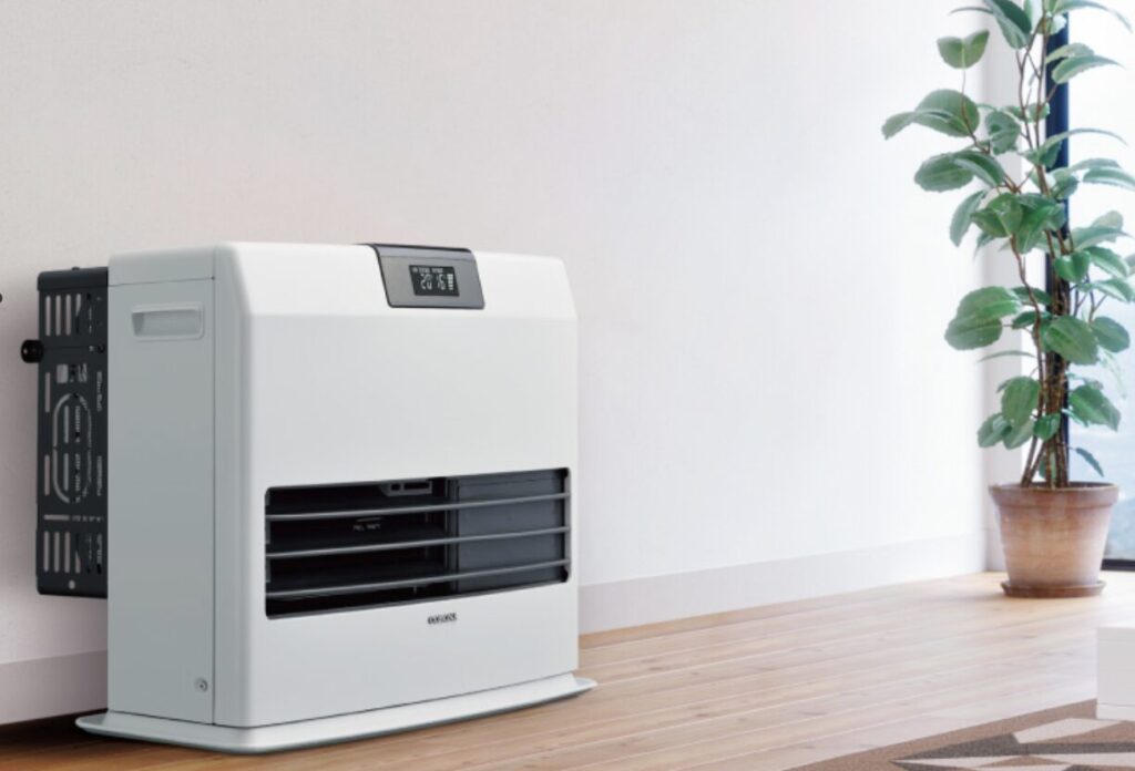 室内に設置された白いファンヒーターと観葉植物が並ぶシンプルな空間