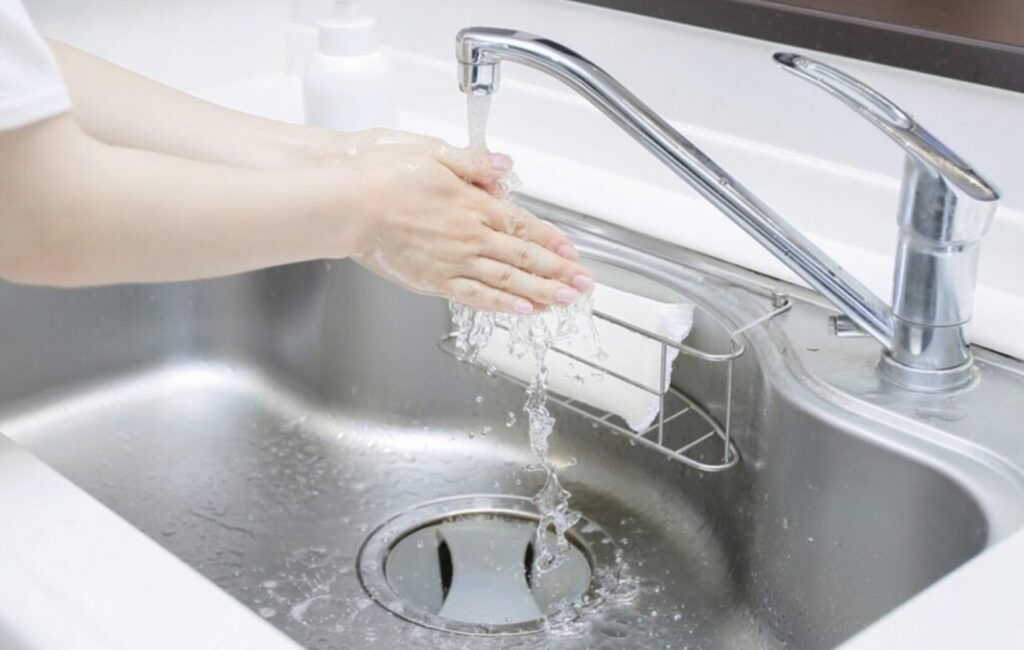 シンクで手を洗っている様子と流れる水