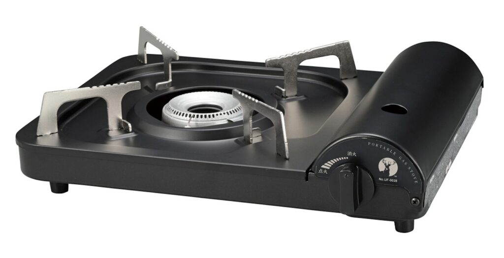 カセットコンロ本体のバーナーと五徳部分を斜めから写した黒色の卓上ガスコンロ