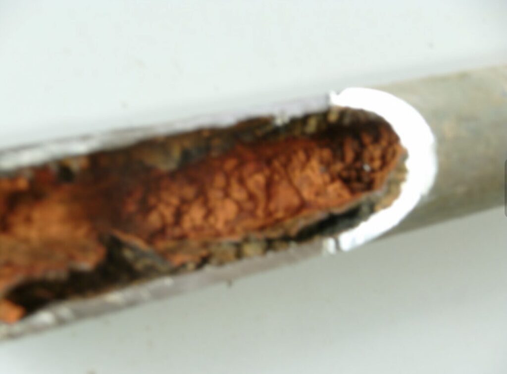 配管内部に赤錆が大量に付着し、鉄管が腐食している様子