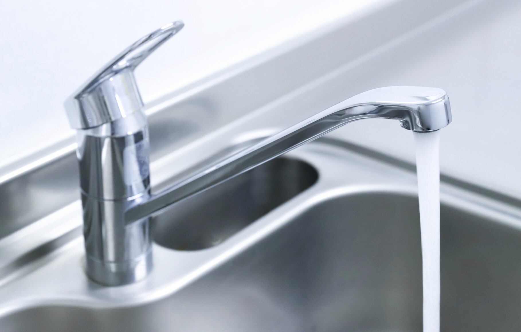 キッチンのシンクで蛇口から透明な水が流れている様子