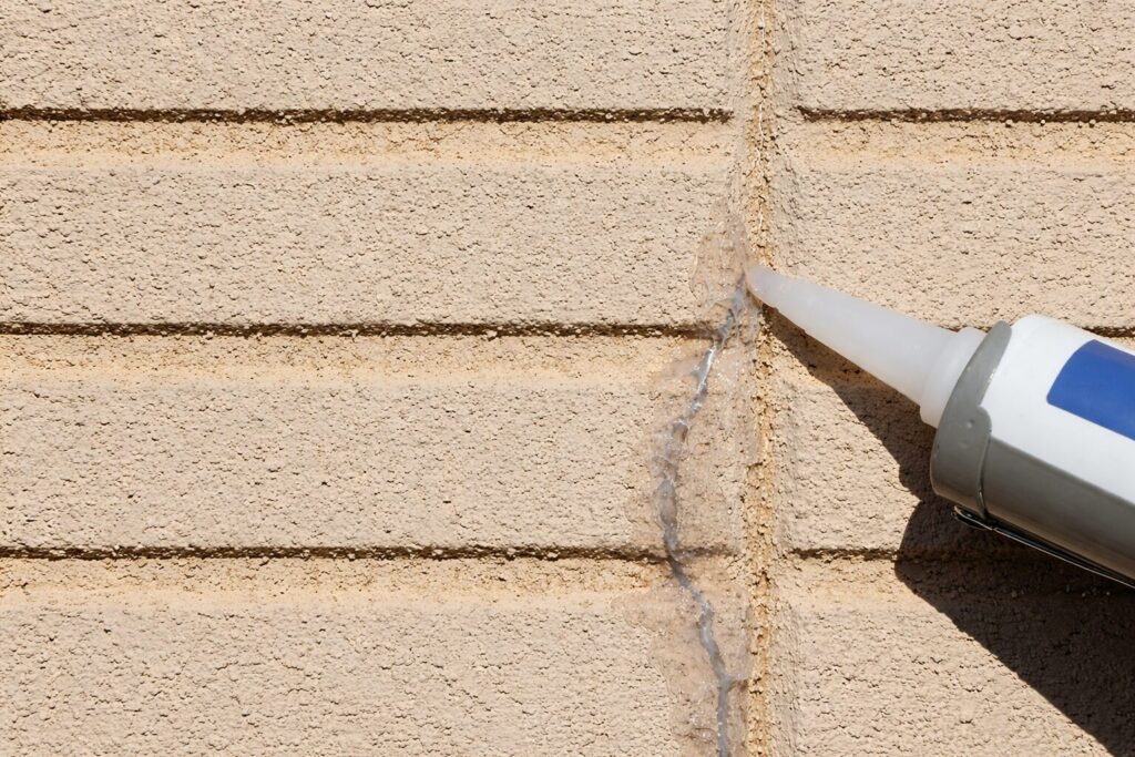 外壁のひび割れにコーキング剤を充填して補修している様子