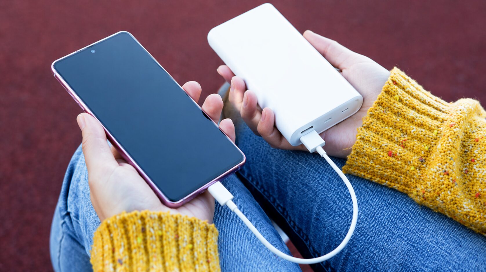 モバイルバッテリーでスマートフォンを充電している様子の手元の写真