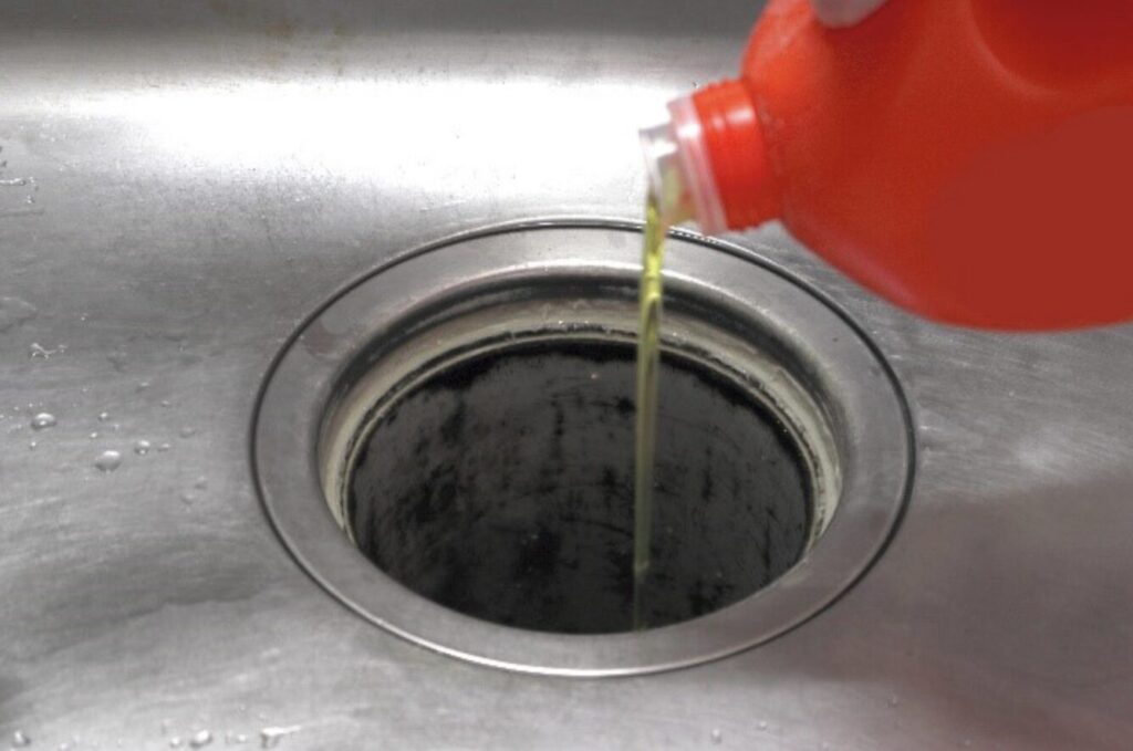 排水口に液体洗剤を注いで油汚れを分解している様子
