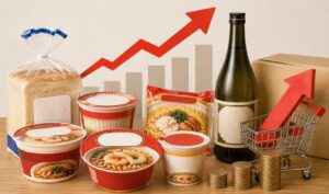 食品や日用品の値上げをイメージしたパン・カップ麺・飲料と、上昇するグラフや矢印が配置されたイラスト。物価上昇や大手メーカーによる価格改定の雰囲気を表現している。